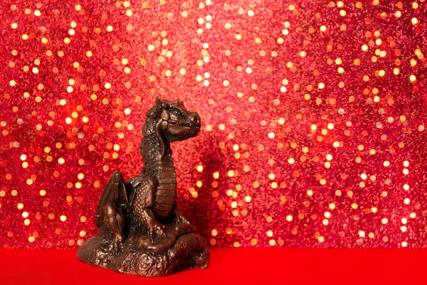 青铜龙喜庆的红色闪闪发光的背景。圣诞贺卡。中国新年2024背景与龙雕像图片下载