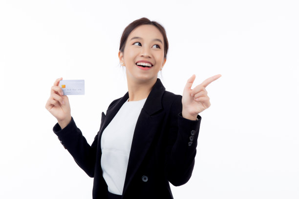 画像中年轻的亚洲女商人手持信用卡或借记卡展示，并以孤立的白色背景呈现女商人网上购物和支付、金融和银行理念。图片下载