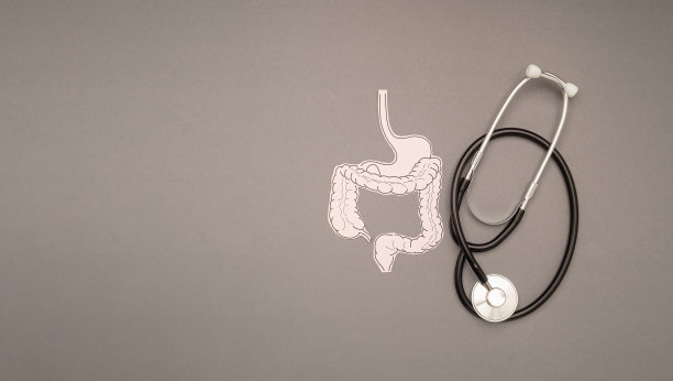 一个听诊器和大肠形状的纸在灰色的背景图片下载