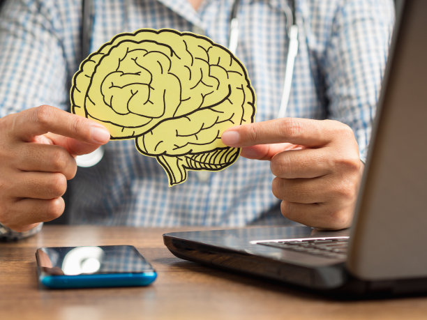 医生手里拿着一个黄纸做的大脑模型图片下载