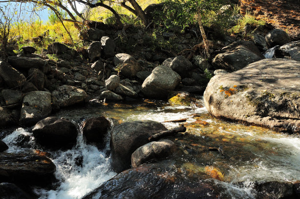 瀑布:在美丽的山溪床上的一串小瀑布，在秋天流经黄昏的森林。图片下载