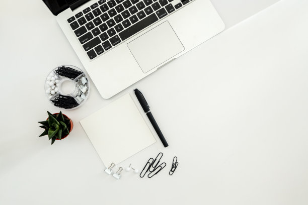 白色办公桌，配有空白笔记本、电脑键盘等办公用品。带复制空间的俯视图，平铺。图片下载