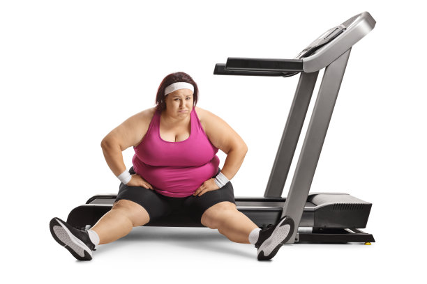 坐在跑步机上的懒惰超重女人图片下载