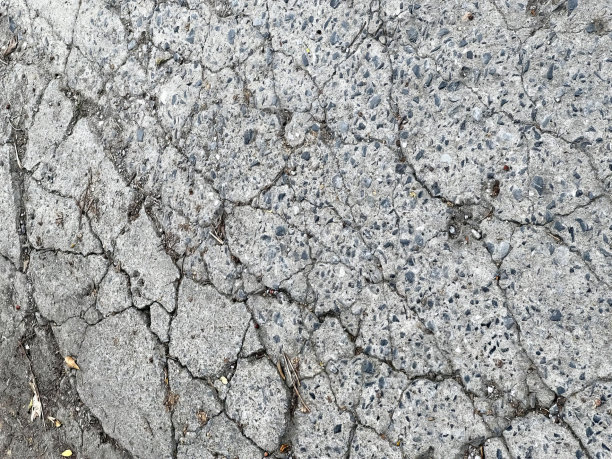 路边的消防栓的照片，混凝土表面布满了裂缝和裂缝。图片下载