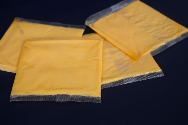 切片的切达奶酪还裹在塑料里。图片下载