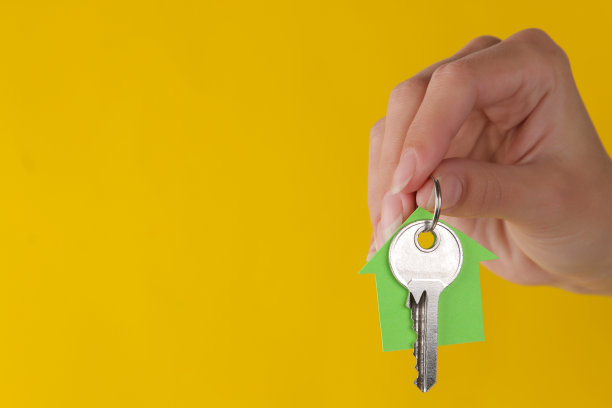 置业概念。黄色背景上的钥匙和钥匙链图片下载