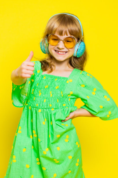 戴着墨镜的小女孩戴着耳机听着音乐，跳迪斯科，玩得很开心图片下载