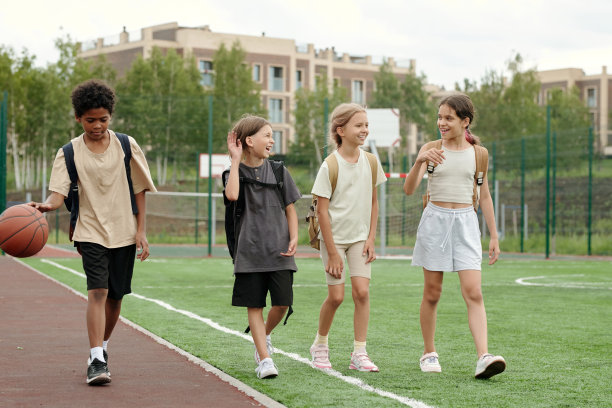 三个兴高采烈的小学生边讨论边笑图片下载