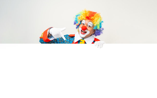 小丑先生。滑稽的脸小丑的肖像在彩色制服站着拿着复印空间。快乐的表情男性傻瓜在各种姿势与框架模型空白空间在孤立的背景。图片下载