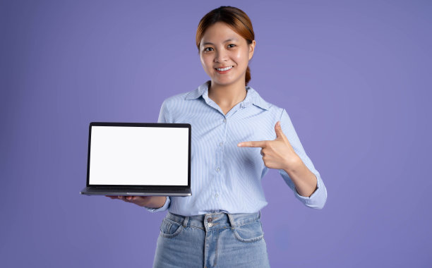 年轻的亚洲商业女孩在紫色背景下使用笔记本电脑图片下载