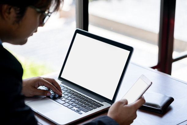 商人使用智能手机共享互联网，笔记本电脑在咖啡店工作图片下载