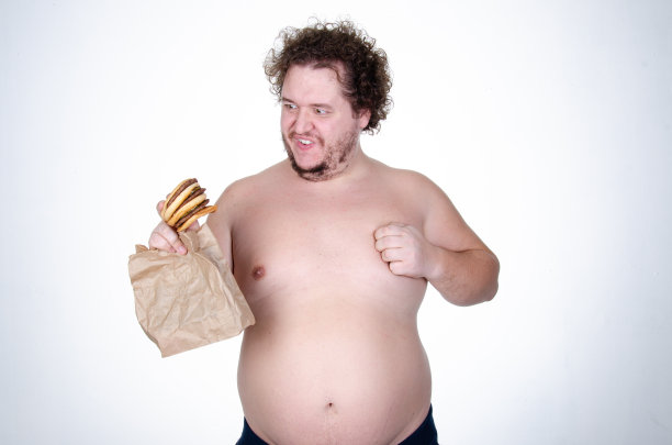 饮食和健康的生活方式。吃汉堡的滑稽胖子。图片下载