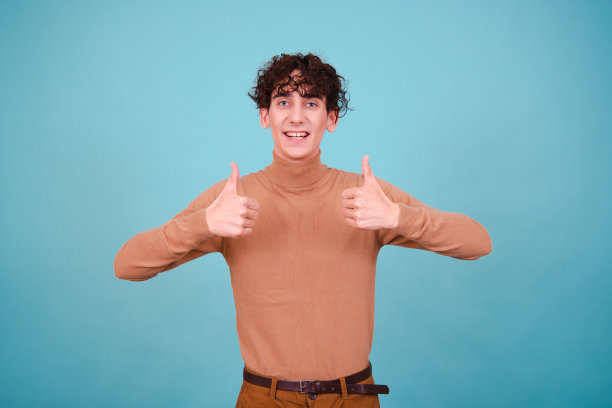 情绪化的家伙在蓝色背景的工作室里摆姿势，既惊讶，又高兴，又悲伤。图片下载