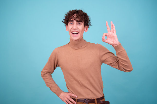 情绪化的家伙在蓝色背景的工作室里摆姿势，既惊讶，又高兴，又悲伤。图片下载