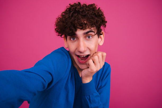 运动和健康的生活方式。有趣的情绪化的家伙在粉红色的背景上摆姿势。图片下载