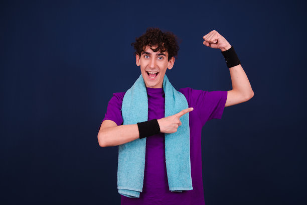 有趣的情绪化的家伙在健身。学生在蓝色背景上摆姿势。图片下载