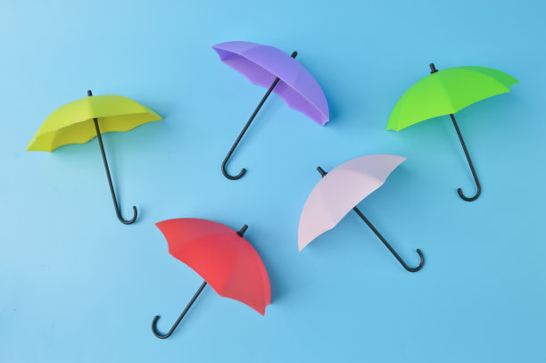 蓝色背景上的彩色玩具伞图片下载