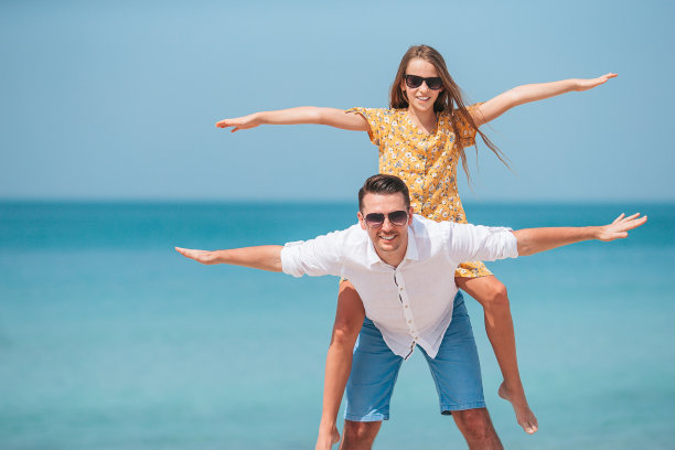 小女孩和快乐的爸爸在海滩度假图片下载