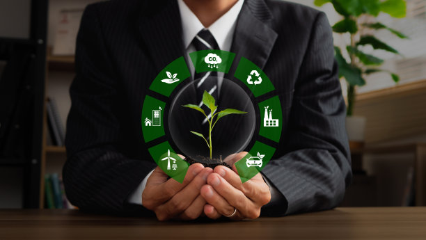 商人手持印有绿色企业ESG、二氧化碳和净零标志的工厂。可持续发展的概念，可持续发展目标，绿色技术，世界地球日和环境技术。图片下载