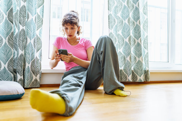 十几岁的女孩在家里用智能手机打发空闲时间图片下载