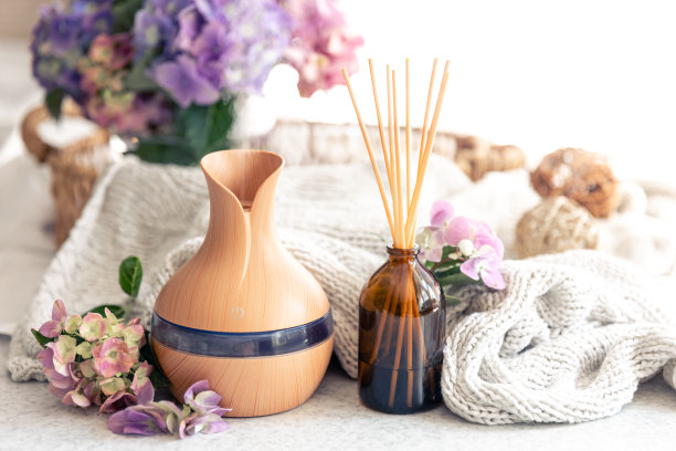 芳香油扩散灯，花朵和针织元素在一个模糊的背景。图片下载