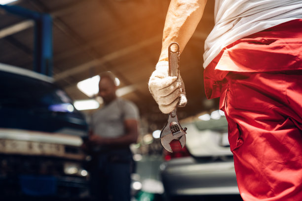 汽车修理工在汽车修理厂用扳手修理和保养汽车发动机的问题特写。图片下载