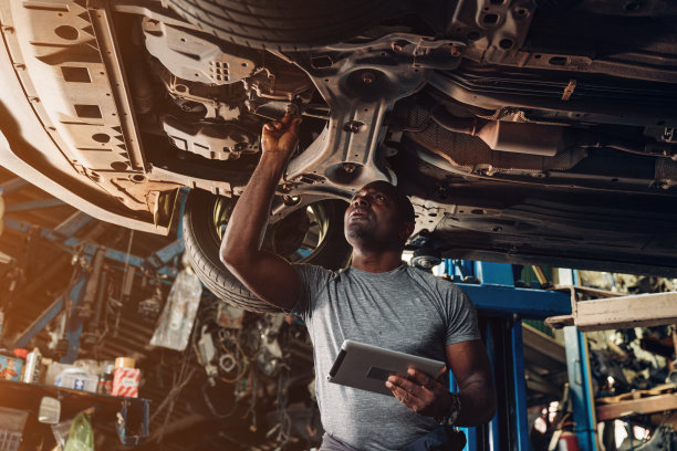 汽车修理工在汽车修理店检查和维修汽车发动机的问题。图片下载