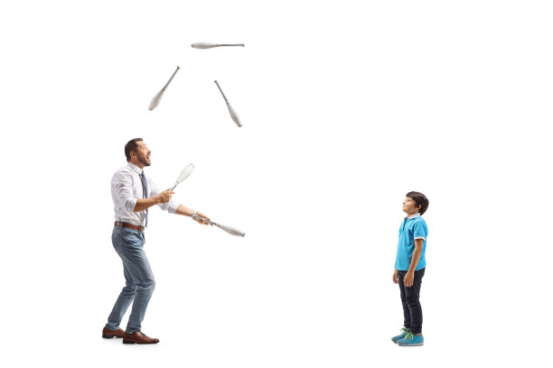 一个男孩看商人耍杂耍的全长侧面照图片下载