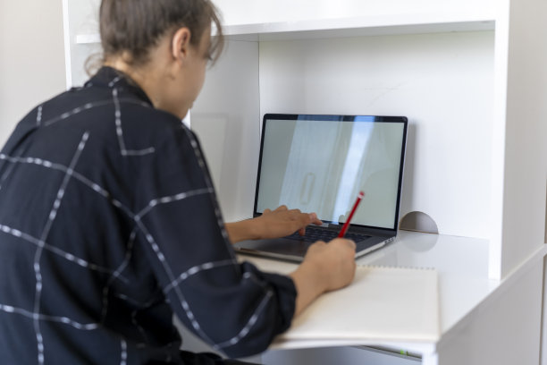 一个正在学习的女孩。小学生用电脑学习。女学生在家做作业。回到学校。图片下载