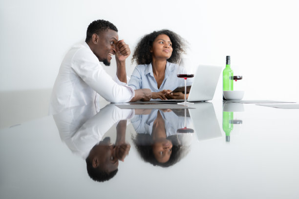 这两个年轻的企业都喝着葡萄酒，用笔记本电脑分享信息图片下载