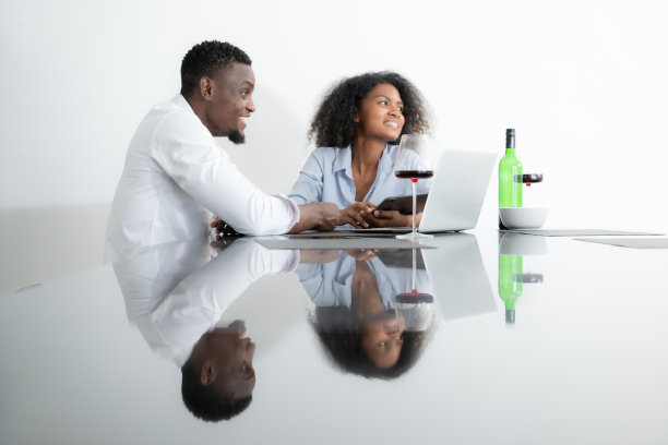 这两个年轻的企业都喝着葡萄酒，用笔记本电脑分享信息图片下载