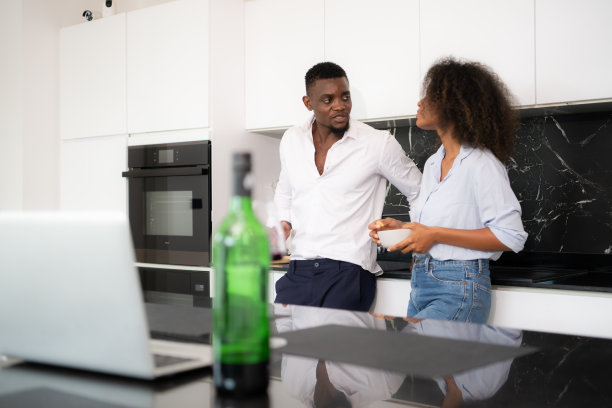 这对年轻夫妇在家里的厨房里用笔记本电脑讨论生意。图片下载