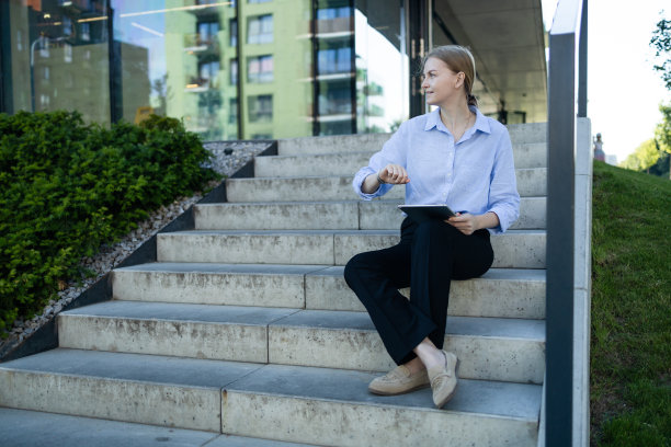 成功的职业女商人的肖像在智能休闲使用数码平板电脑户外城市背景。商务人士的概念。图片下载