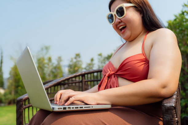 肥胖女人假期旅行在笔记本电脑上工作inÂ酒店度假度假远程在线工作数字自由职业在线学习e-learningÂ图片下载