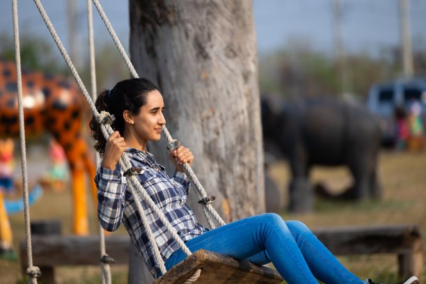 一对热恋中的情侣坐在秋千上。爱,的关系。西班牙裔拉丁男性和女性图片下载