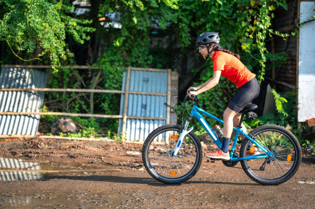 年轻的运动自行车手骑着她的山地车在泥泞的小路上图片下载