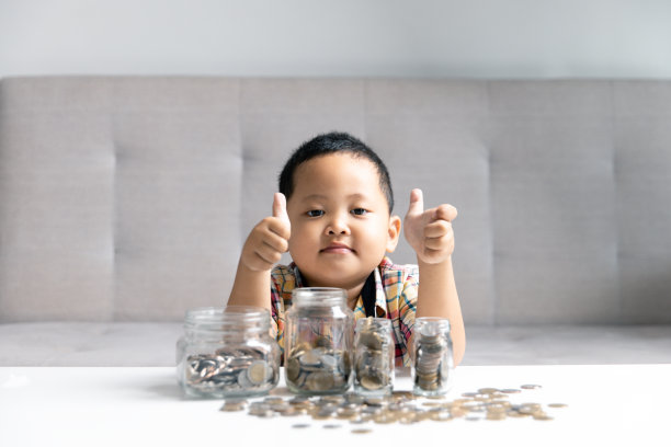 学龄前儿童学习计算个人预算、理财、玩投资、算账。专心读书的孩子存钱买东西，把钱放在家里的粉色存钱罐里。图片下载