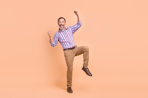 在米色的背景上，高高兴兴的银行家男子举起拳头凯旋，空出一片空间图片下载