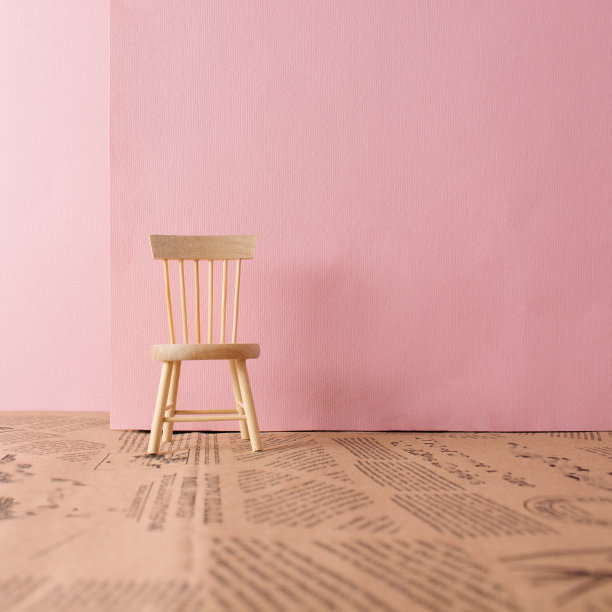 浅色粉色背景下的木椅。最小的概念组成。图片下载