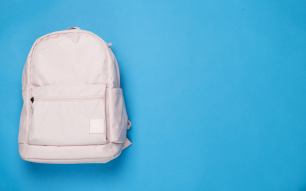 粉红色的学校背包在彩色背景，俯视图图片下载