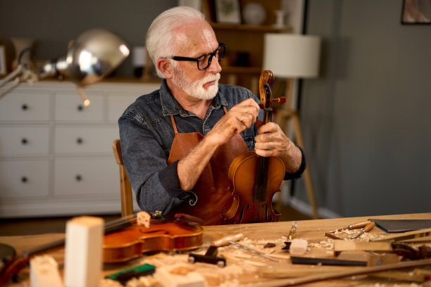 资深木工工匠雕刻木材和制作小提琴乐器图片下载