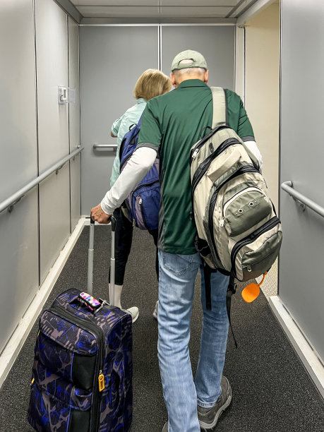 一对成熟的夫妇走过机场的喷气桥图片下载