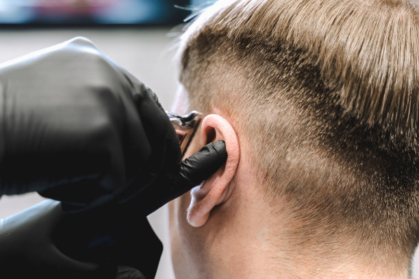 去理发店。男人做时尚的发型、发型。剃去寺庙,。理发师理发推子图片下载