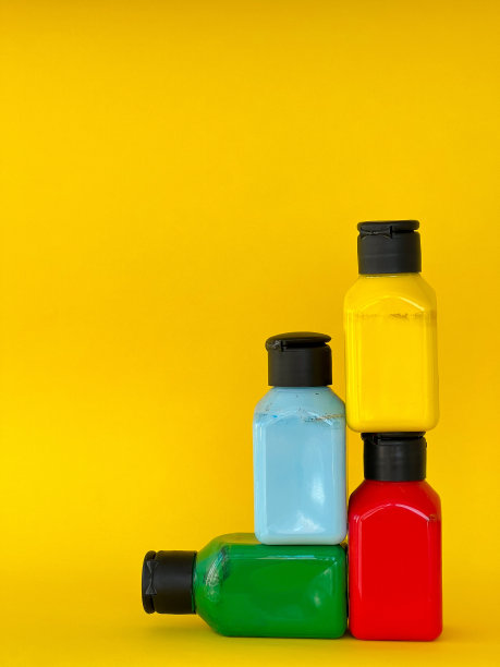 明亮的多色丙烯酸油漆在黄色背景的罐子。静物画图片下载