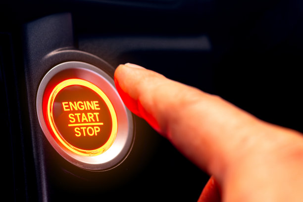 驾驶员的手正在按汽车启动按钮。交通和技术的概念图片下载