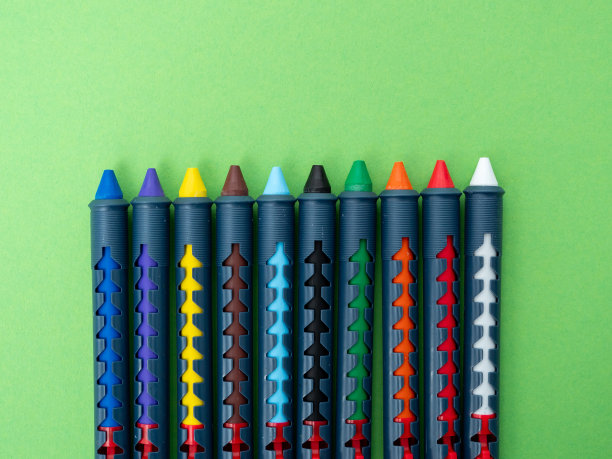 用于在绿色背景上作画的多色蜡笔。图片下载