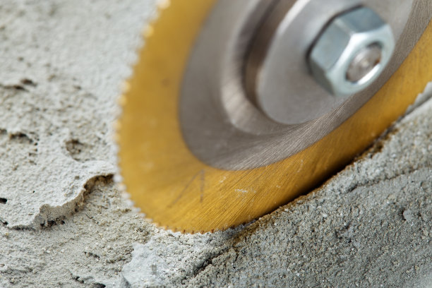 涂有金刚石涂层的金属锯、立铣刀或钻头在混凝土板上打孔。工业和建筑业。图片下载