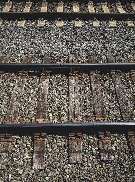 从上面看，砾石中的木制火车轨道图片下载
