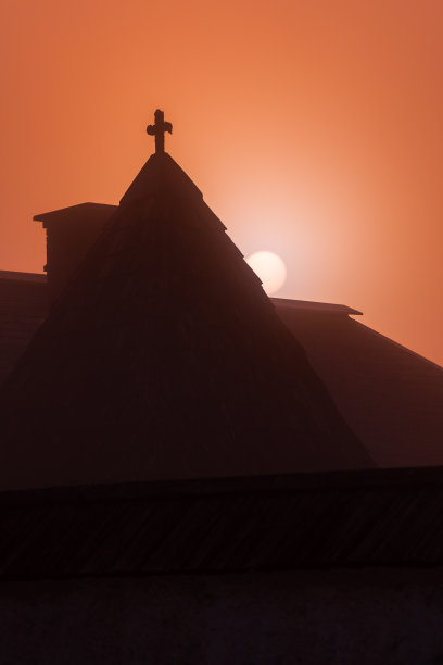 斯洛文尼亚博希尼市中世纪教堂屋顶后的黎明和初升的太阳图片下载