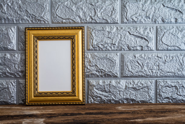 金色的仿古风格相框在旧木桌砖壁纸背景。图片下载